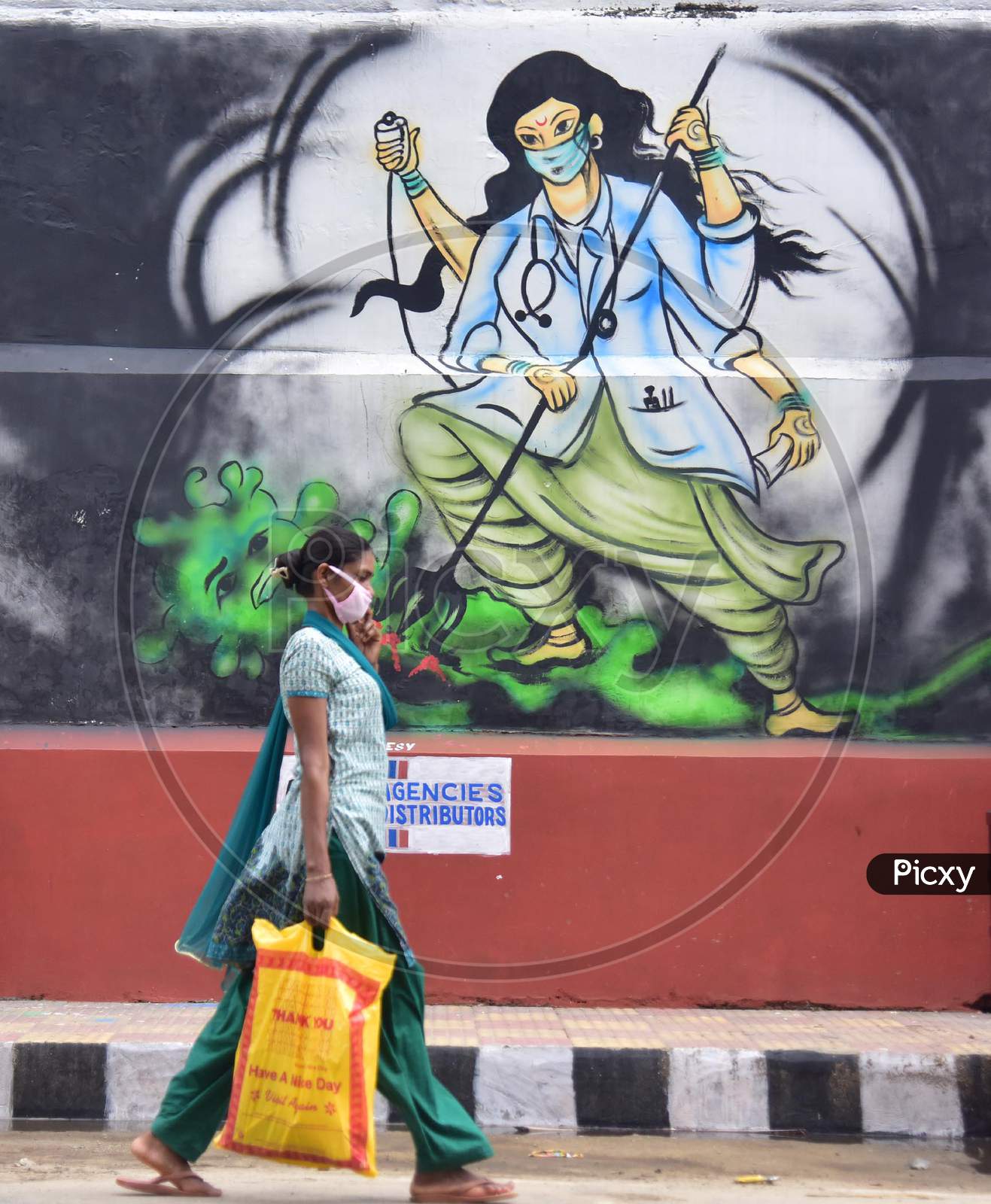 A woman walks Past A Mural  With A Message To Take Precautions Against Coronavirus In Guwahati , India On June 14, 2020.