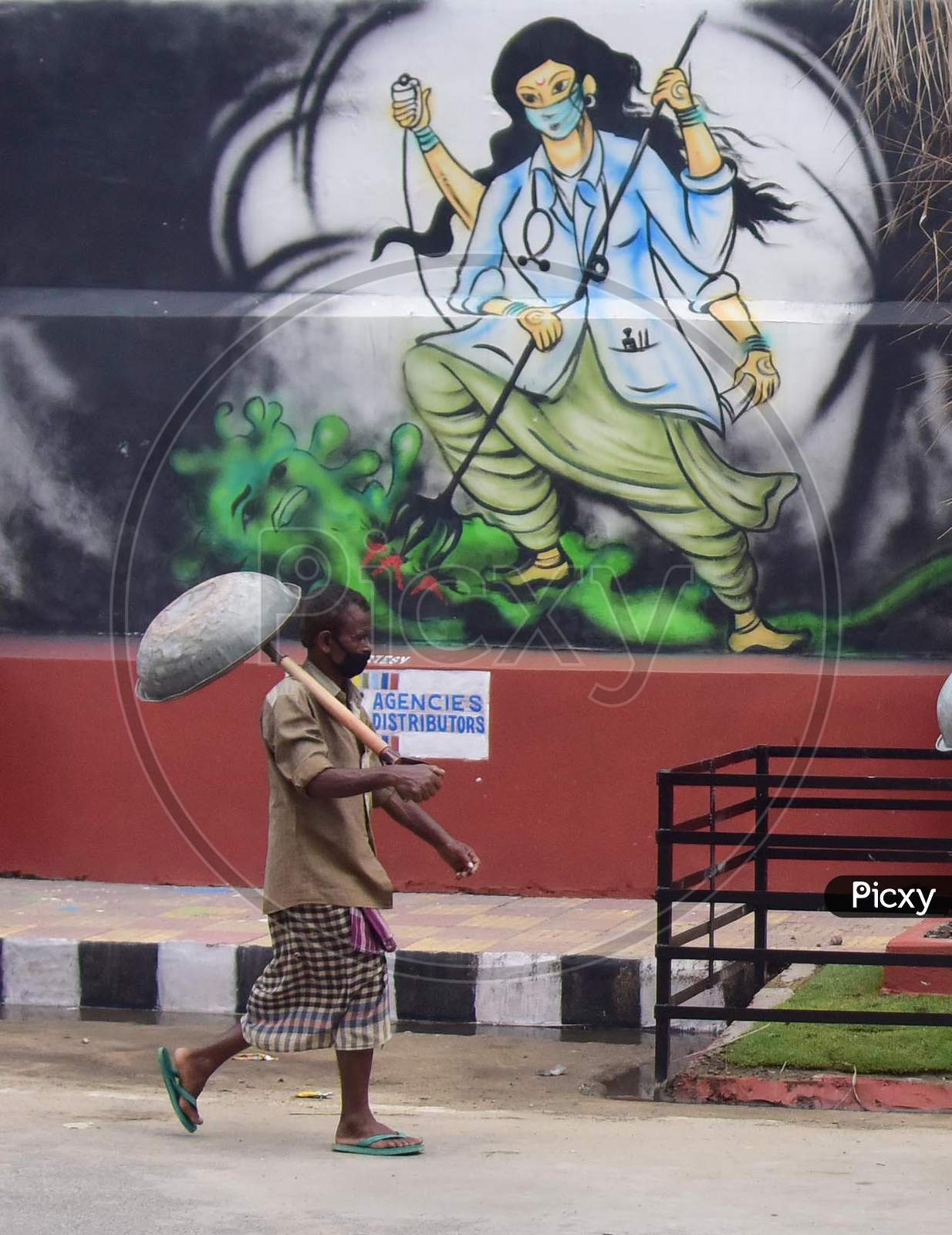 A Labourer walks Past A Mural With A Message To Take Precautions Against Coronavirus In Guwahati, India On June 14, 2020.