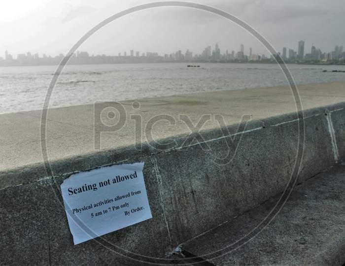 A notice is put up on the promenade at Marine Drive saying "seating is not allowed" after some restrictions were lifted in Mumbai, India on June 6, 2020.