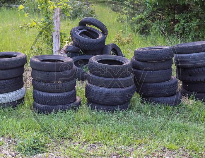Damaged and worn old black tires on a stack. Tire tread problems. Solutions concept. Tire tread problems.