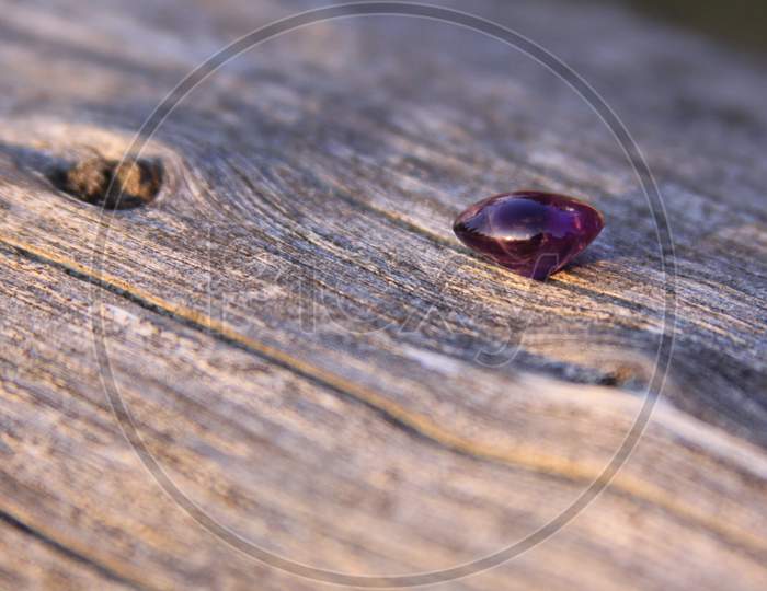 Purple Amethyst Gemstone On Wooden Background