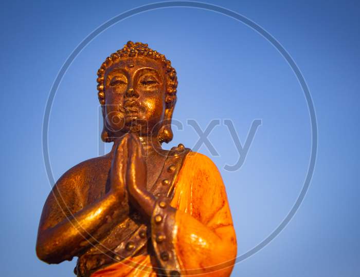 Closeup View Of Buddha Against Blue Sky Background