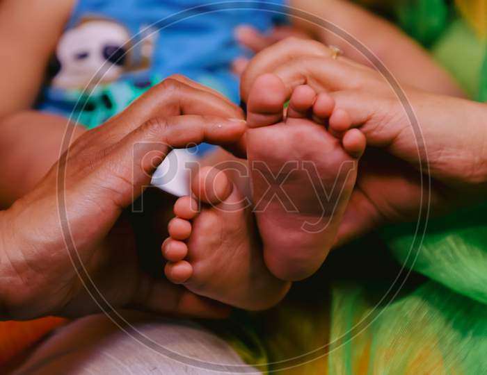 Indian family holding their child feet in their hand