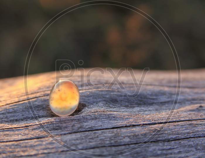 Isolated Chalcedony Agate Gemstone On Wooden Background