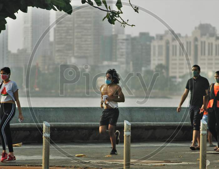 People walk and jog along the promenade at Marine Drive after some restrictions were lifted in Mumbai, India, June 6, 2020.