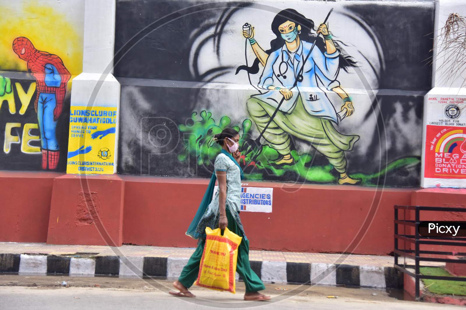 A Woman Walks Past A Wall Graffiti Which Was Made To Honour Medical Workers Who Fight Against The Coronavirus In Guwahati, India On June 14, 2020.