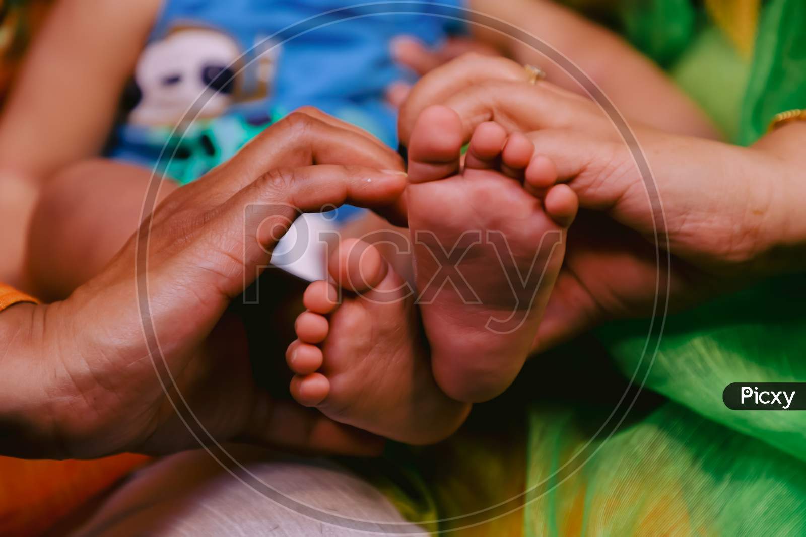 Indian family holding their child feet in their hand