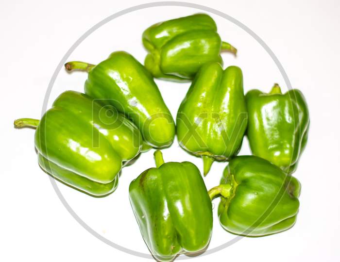 Fresh green capsicum or bell pepper isolated on a white background