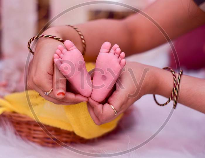 Indian new born child feet held by her mother