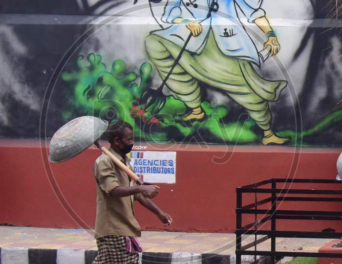 A Labourer walks Past A Mural With A Message To Take Precautions Against Coronavirus In Guwahati, India On June 14, 2020.