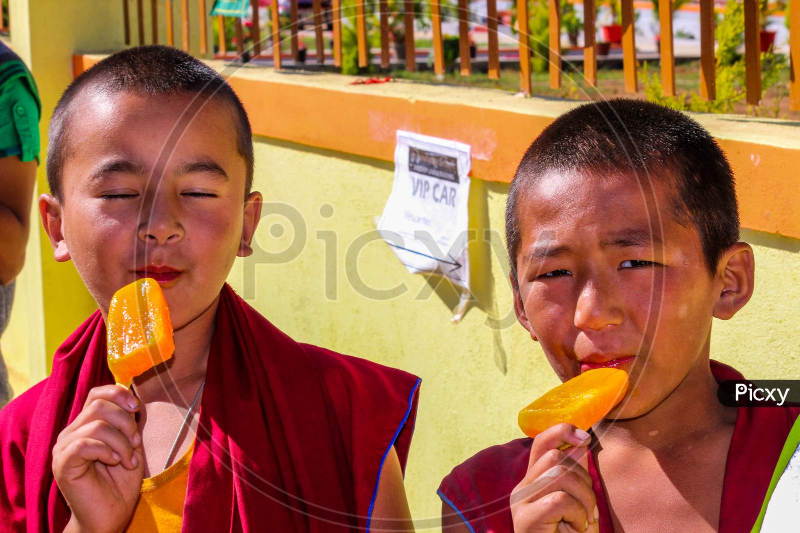 Two Tibetan Kids  relishing Ice candies in Bylukoppa town of Coorg district in Karnataka/India.