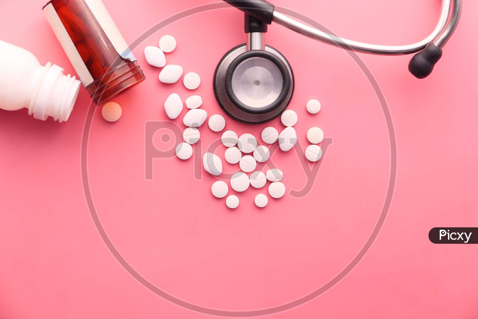 Pills, Stethoscope And Container On Pink Background