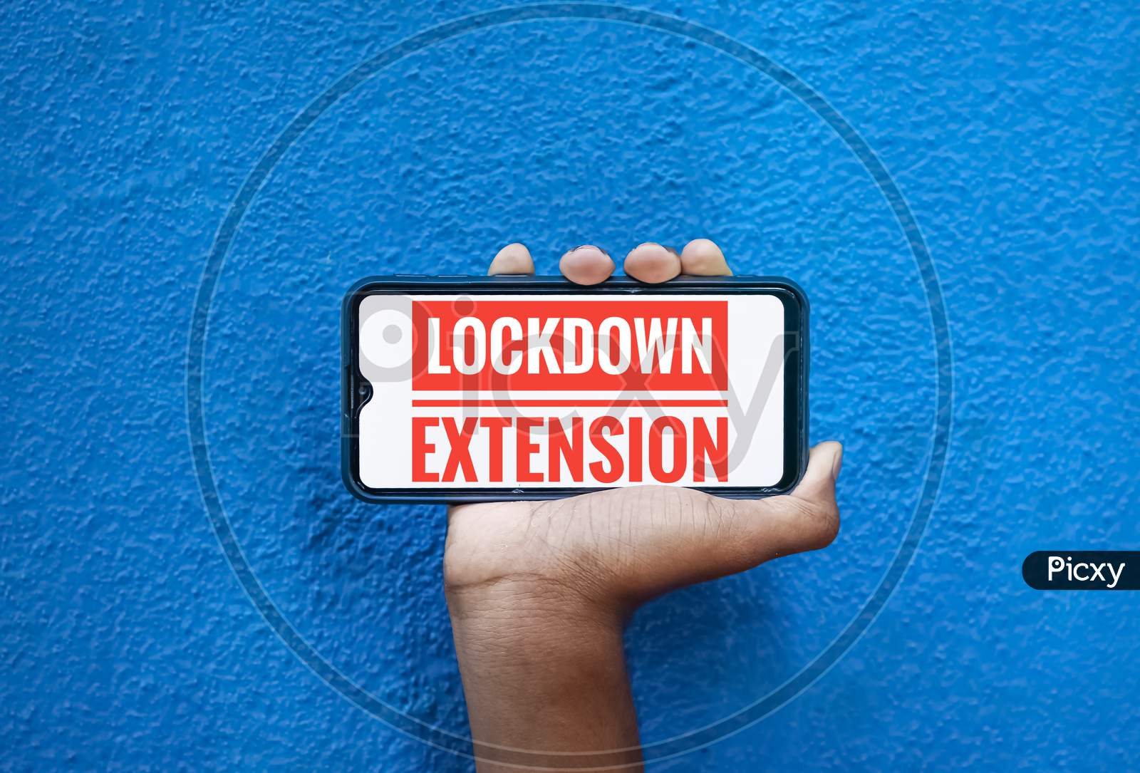 Lock Down Extension Word On Mobile Screen Isolated On Blue Background With Copy Space For Text. Person Holding Mobile On His Hand And Showing Front Of The Screen Wording Lock Down Extension.