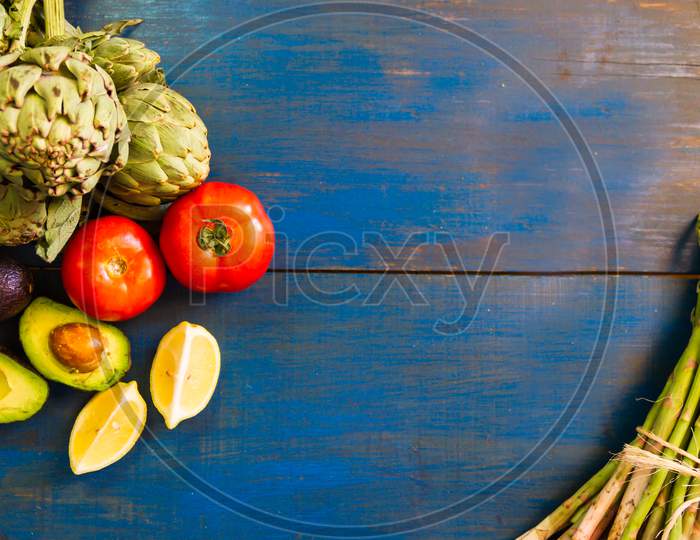 Tomatoes Avocados Artichokes And Asparagus On Blue Rustic Background