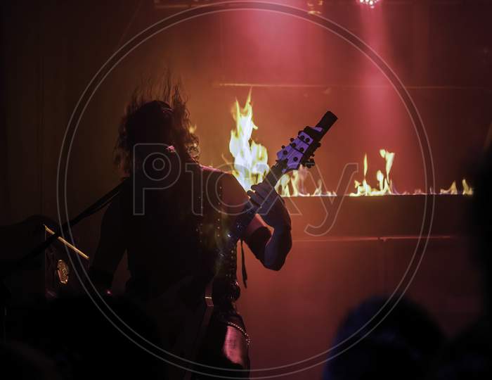 Krakow, Poland - September 20, 2014: An Abstract Of A Man Perform Rock Thrash Metal Music With A Guitar And Flame At The Background
