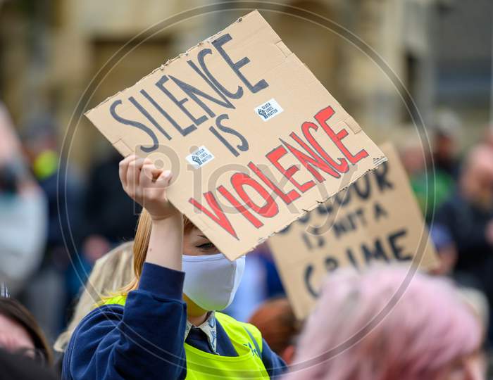 A Protester Wears A Ppe Face Mask And Holds A Homemade Anti Racism Poster High At A Black Lives Matter Protest In Richmond, North Yorkshire