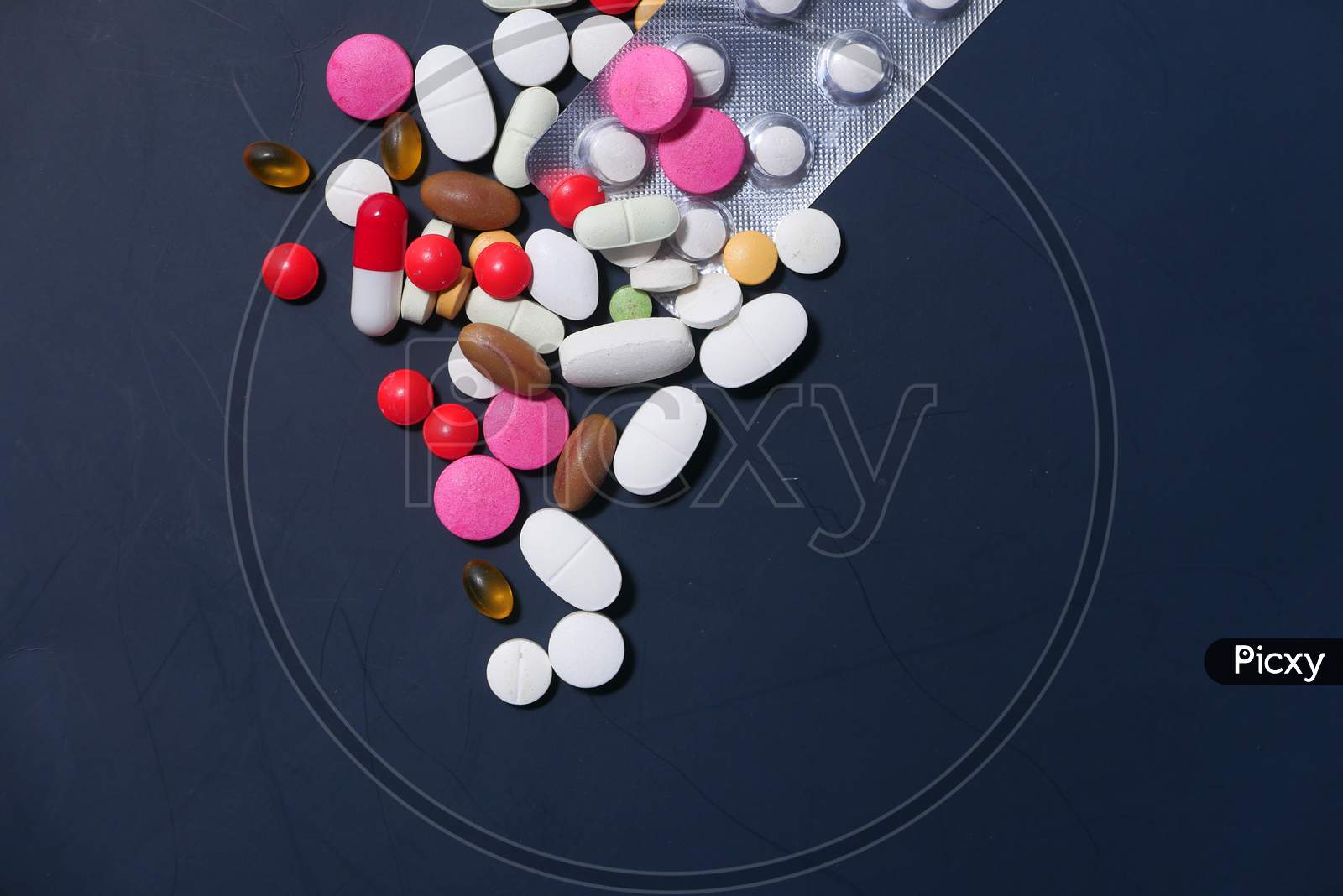 Close Up Of Colorful Pills Spilling On Dray Desk