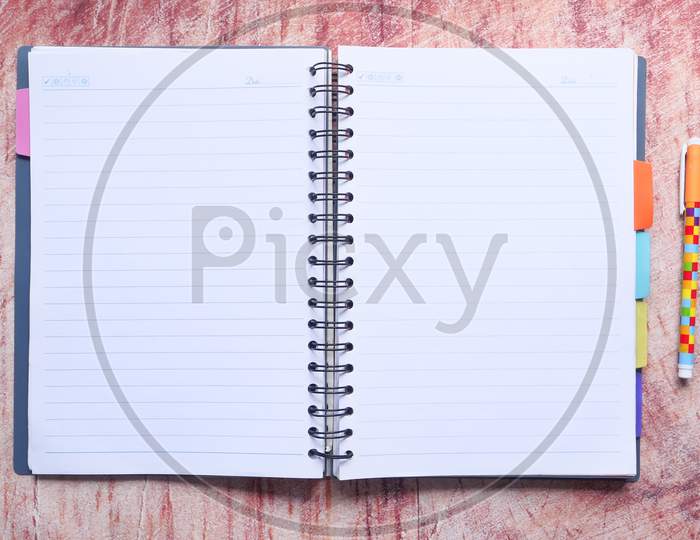 High Angle View Of Open Diary On Wooden Table