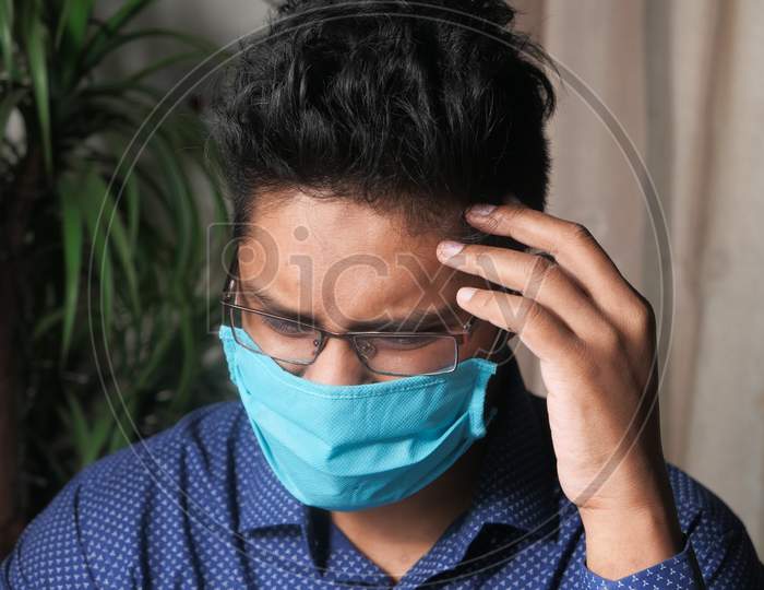 A Young Asian Man Mask On His Face Suffering Headache