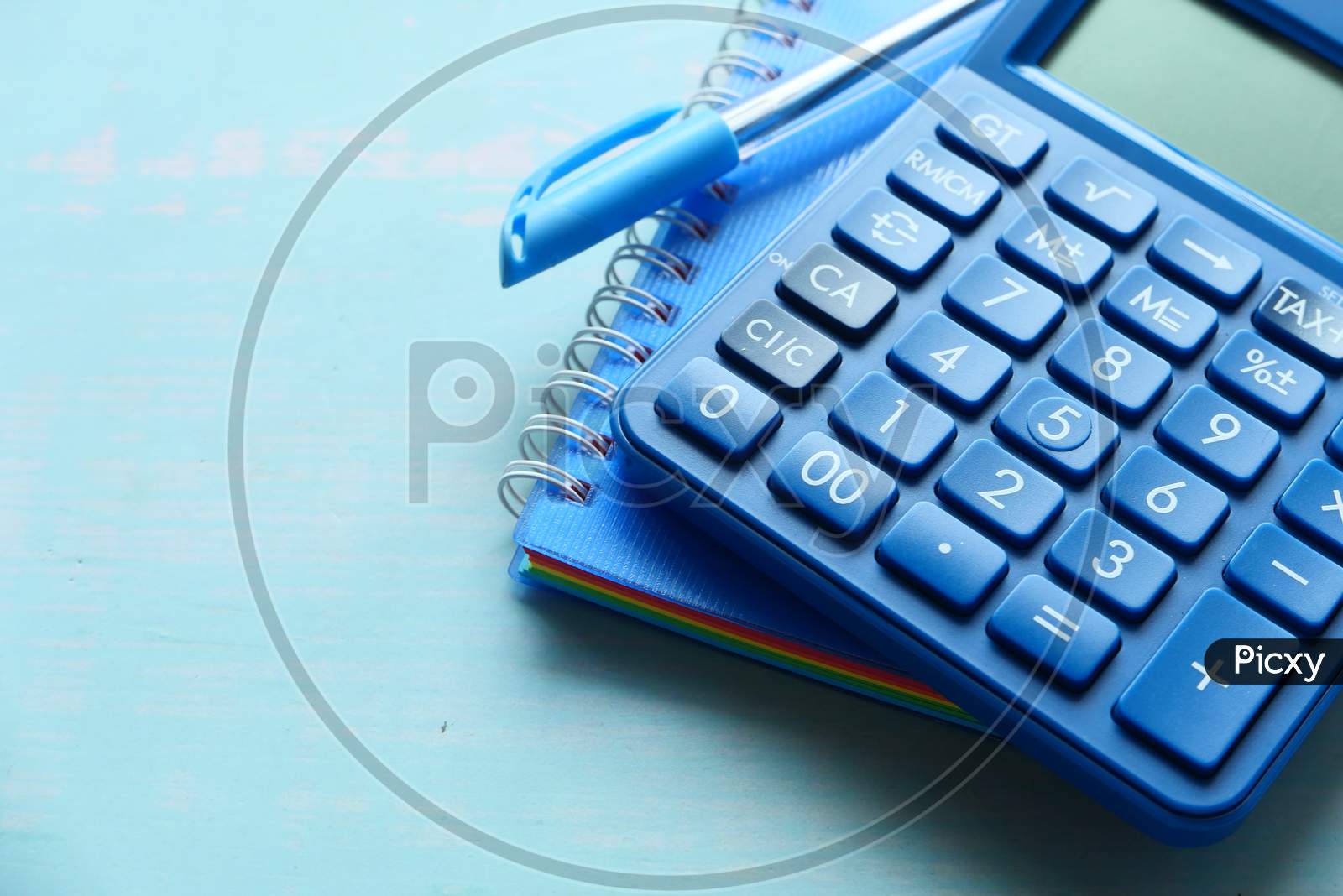 Close Up Of Calculator, Pen And Notepad On Desk