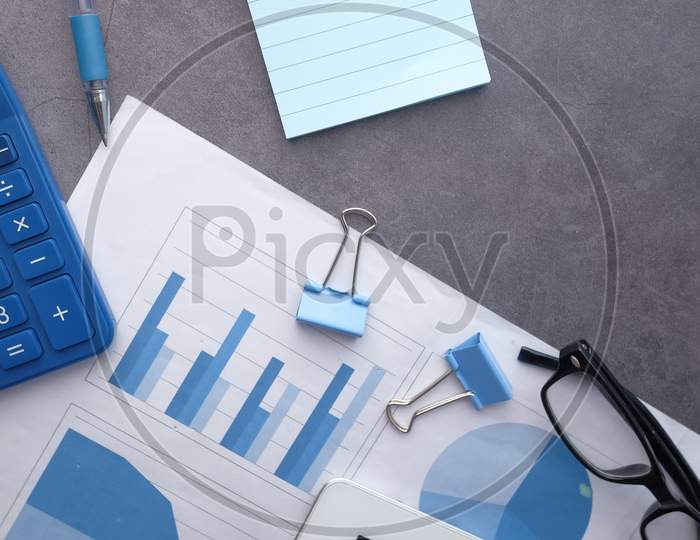 Financial Graph, Calculator And Notepad On Table, Using Self Created Chart
