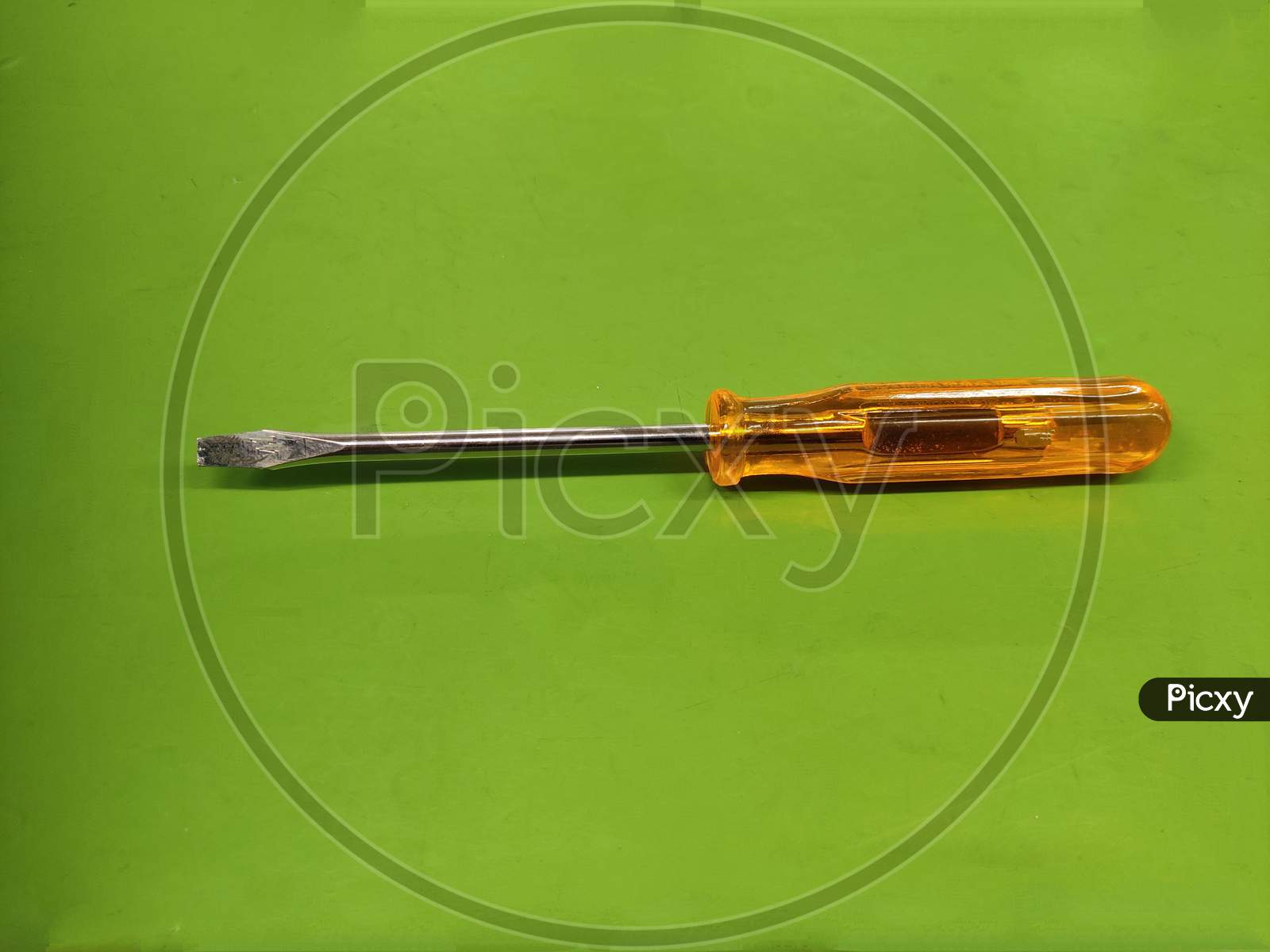 Screw Driver minus slotted head Isolated on green background.
