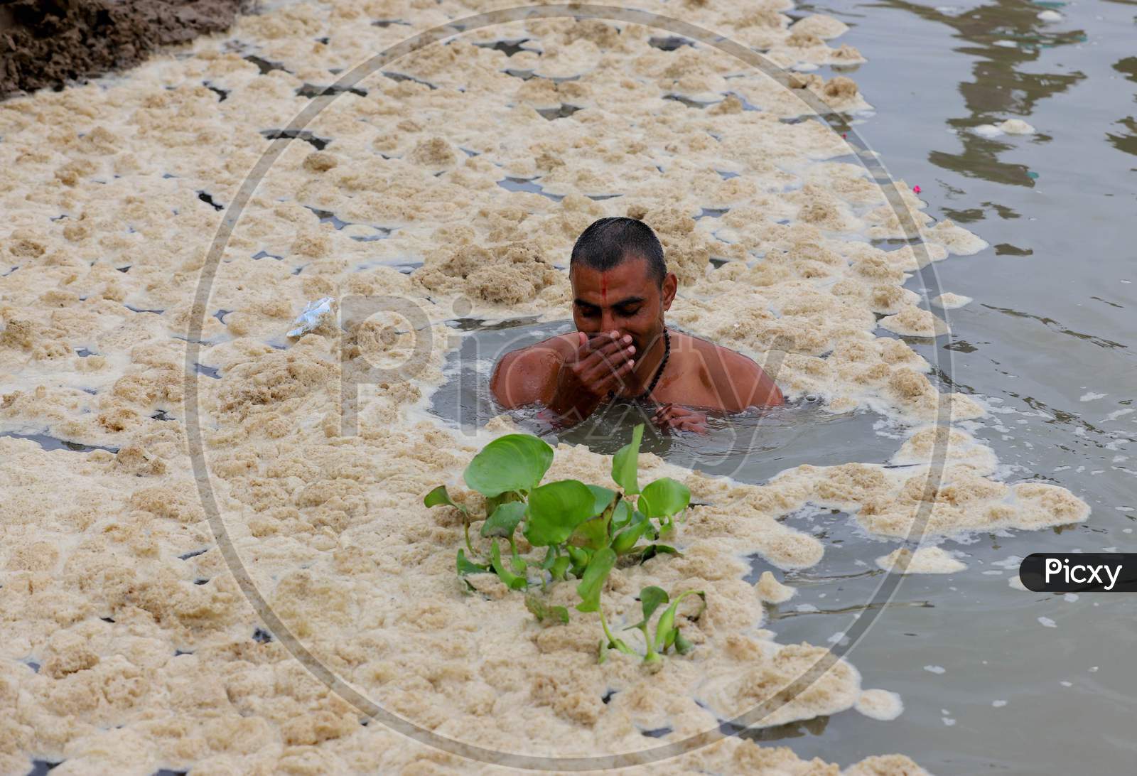 A Hindu Devotee Takes Holy Dip In The Polluted Water Of Ganga River In Prayagraj, June 14, 2020.