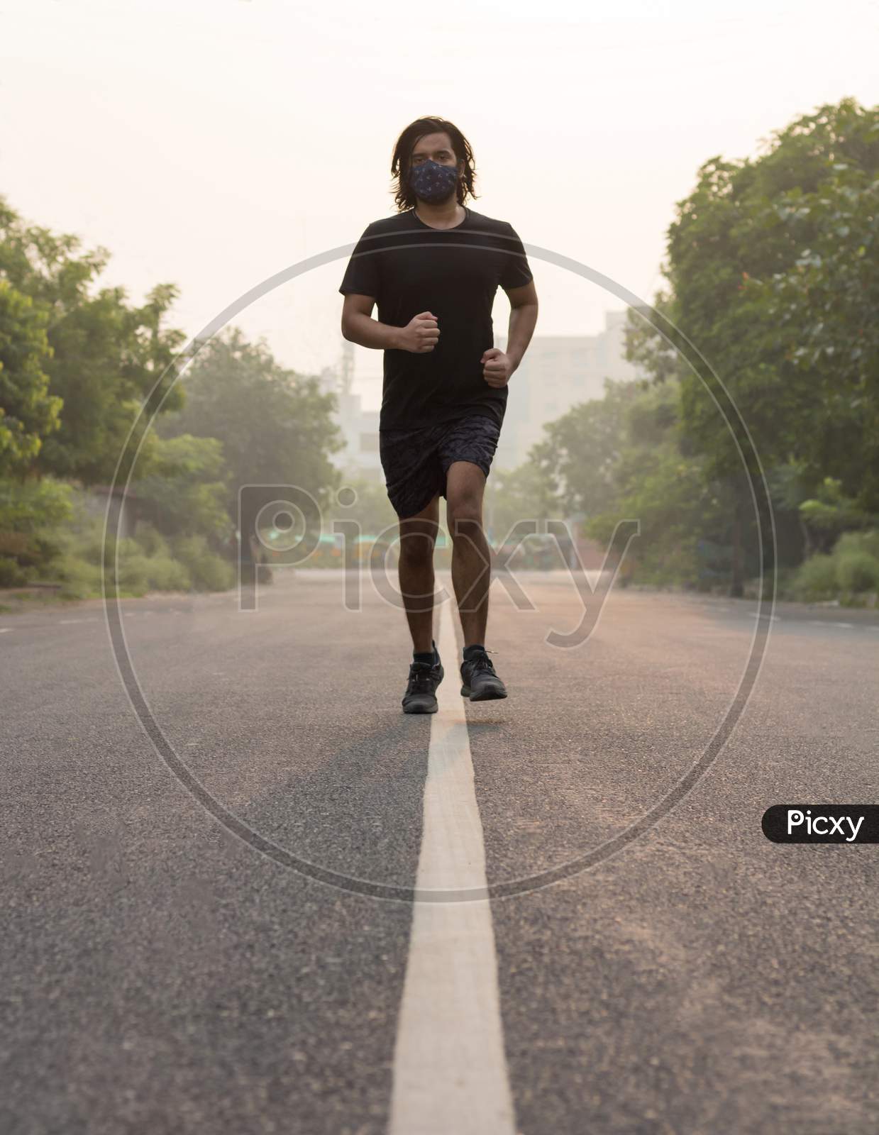 A Man Running While Wearing Mask In The Morning.