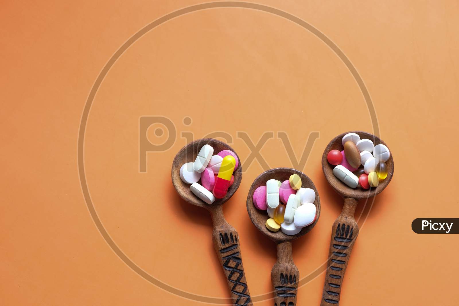 High Angle View Of Pills On Spoon On Orange Desk
