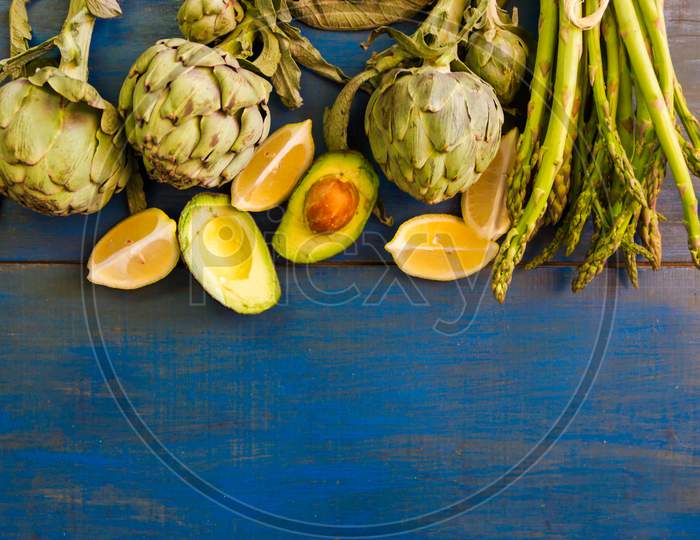 Artichoke Avocados And Asparagus On Blue Rustic Background