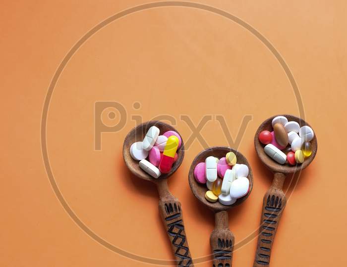 High Angle View Of Pills On Spoon On Orange Desk