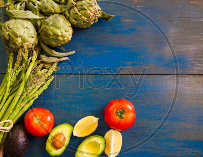 Tomatoes Avocados Artichokes And Asparagus On Blue Rustic Background