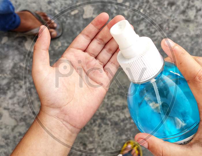 Closeup of a boy sanitizing his hand.