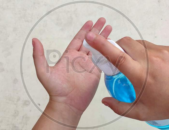 Closeup of a boy sanitizing his hand.isolated with white background
