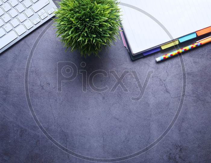 High Angle View Of Notepad, Keyboard On Gray Background With Copy Space