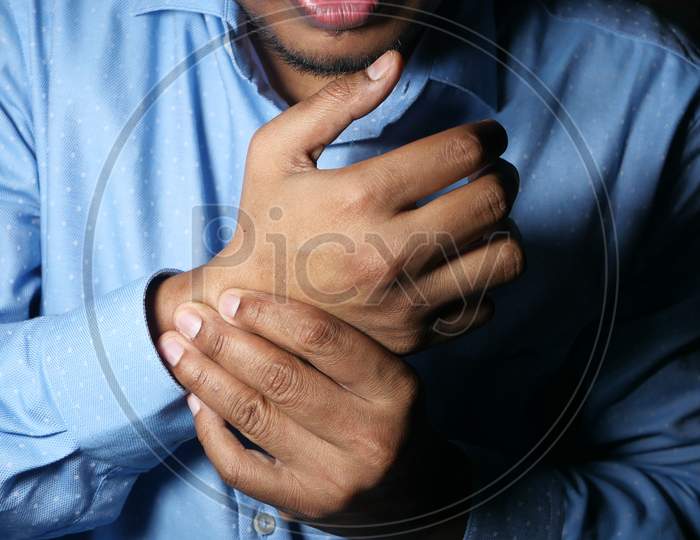 Young Man In Blue Shirt Suffering Wrist Pain