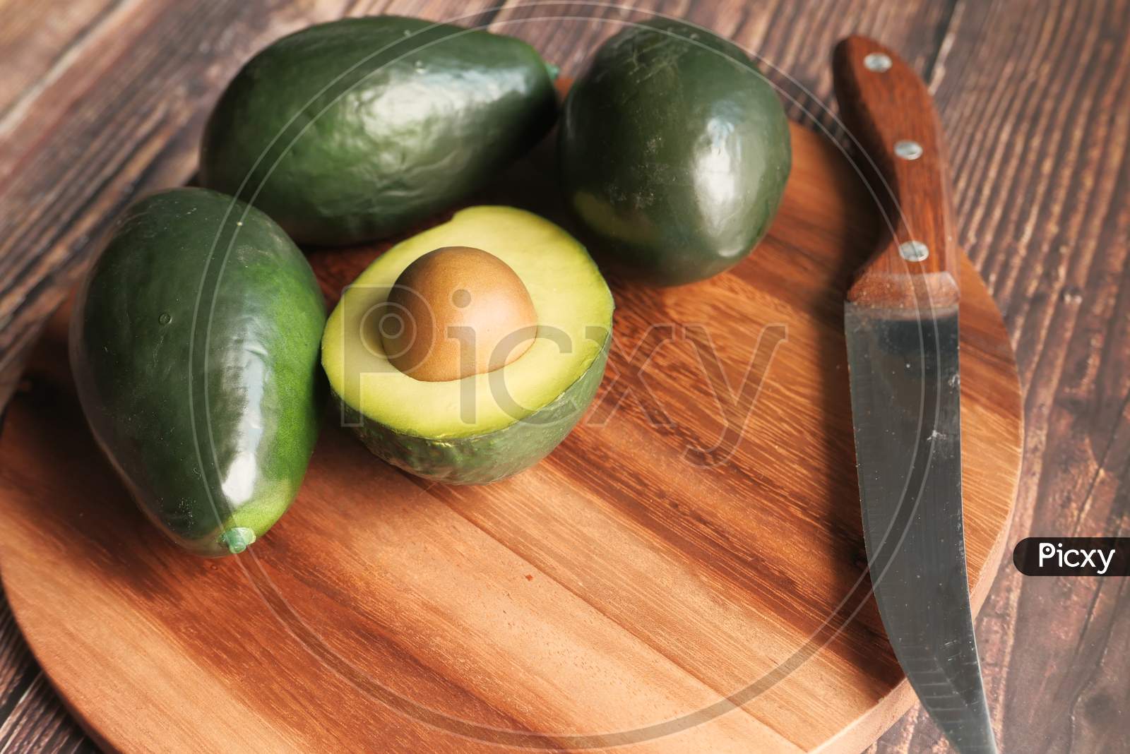 Close Up Of Slice Of Avocado On Chopping Board.