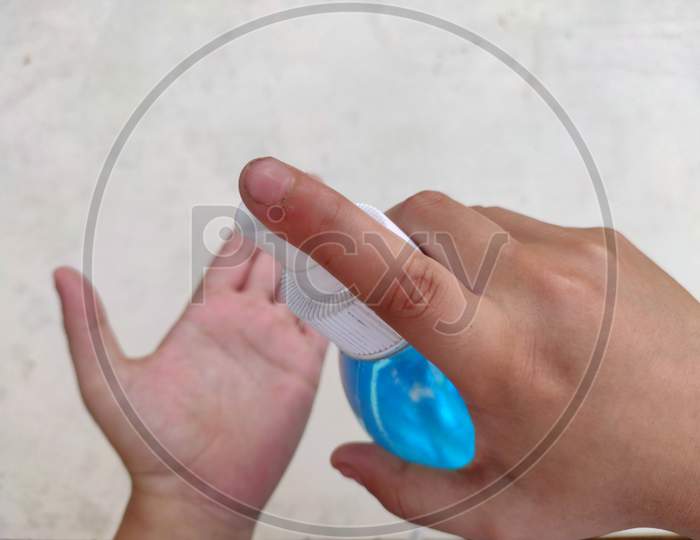 Closeup of a boy sanitizing his hand.isolated with white background