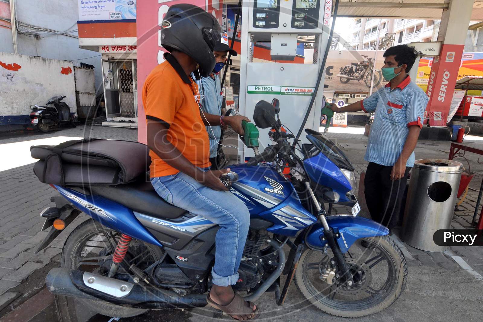 A Petrol Pump Attendant Fills A Motorbike's Tank During In Guwahati On June 15,2020