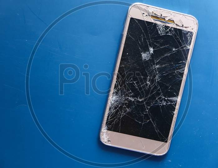 Top View Of Broken Smart Phone On Color Background