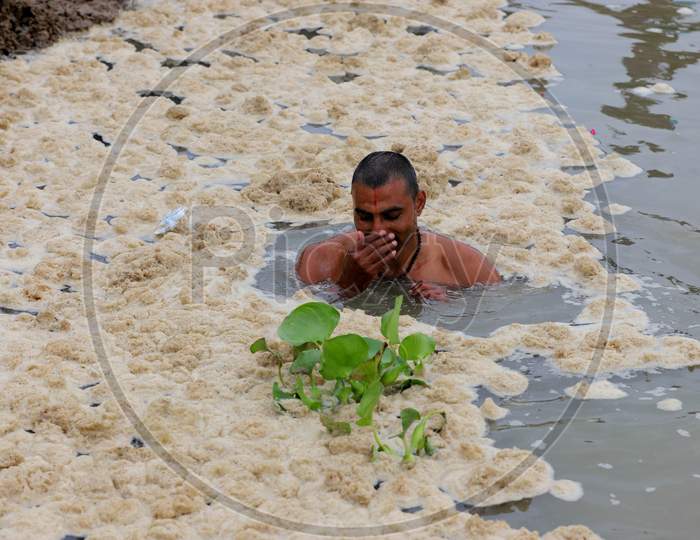 A Hindu Devotee Takes Holy Dip In The Polluted Water Of Ganga River In Prayagraj, June 14, 2020.