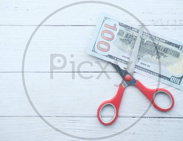 Scissors Cutting A 100 Dollars Banknote, Close Up