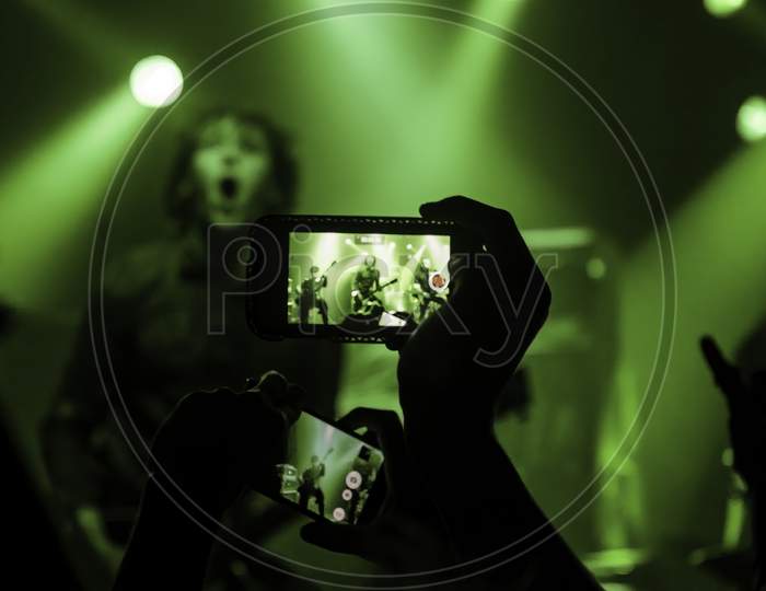 Krakow, Poland - September 20, 2014: Abstract Background Art Of A Cellphone Camera Capturing An Artist Performing Rock Music Concert