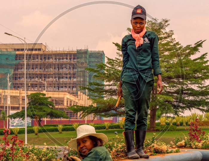 Kigali,Rwanda - October 19,2017: Kn 5 Road Two Female African Gardeners Were Doing Their Hard Work On The Green Roundabout.