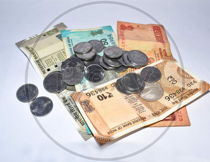 Pile Of Indian Currency Notes And Coins On White Background. Artistic Blur Effect Applied.