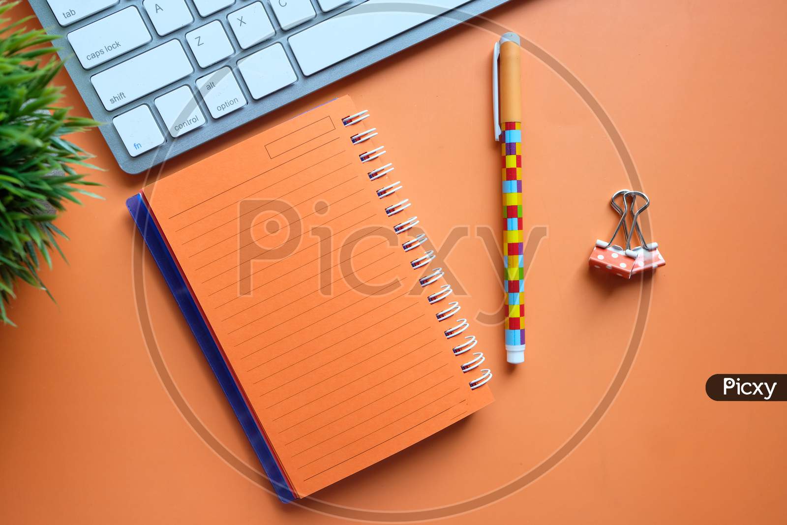 Orange Color Notepad, Keyboard, Pen On Desk