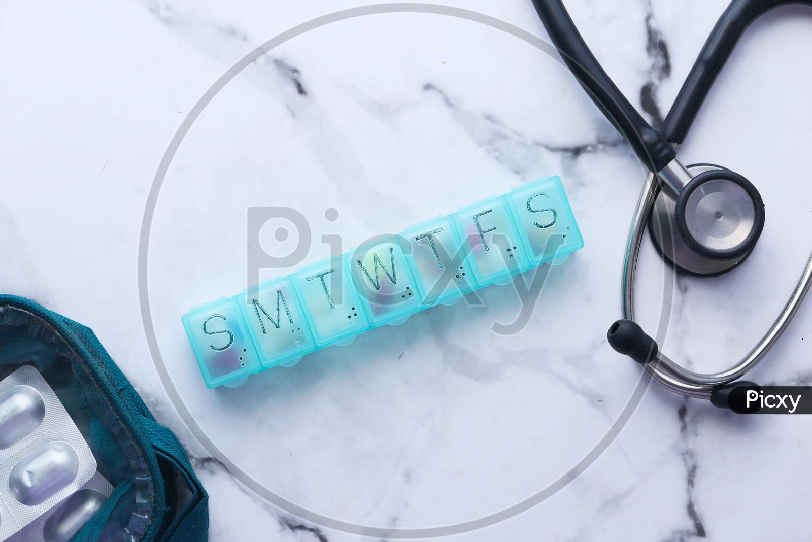 Top View Of Pill Box And Stethoscope On White Background
