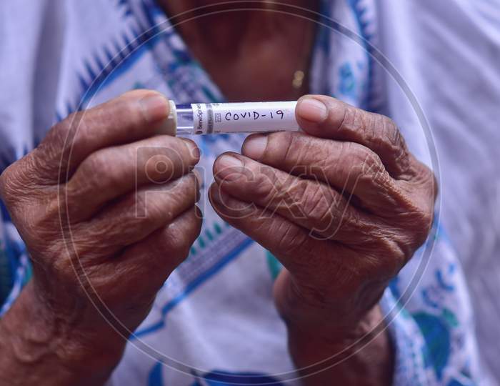 An old indian woman holding a testing kit of coronavirus of her hand