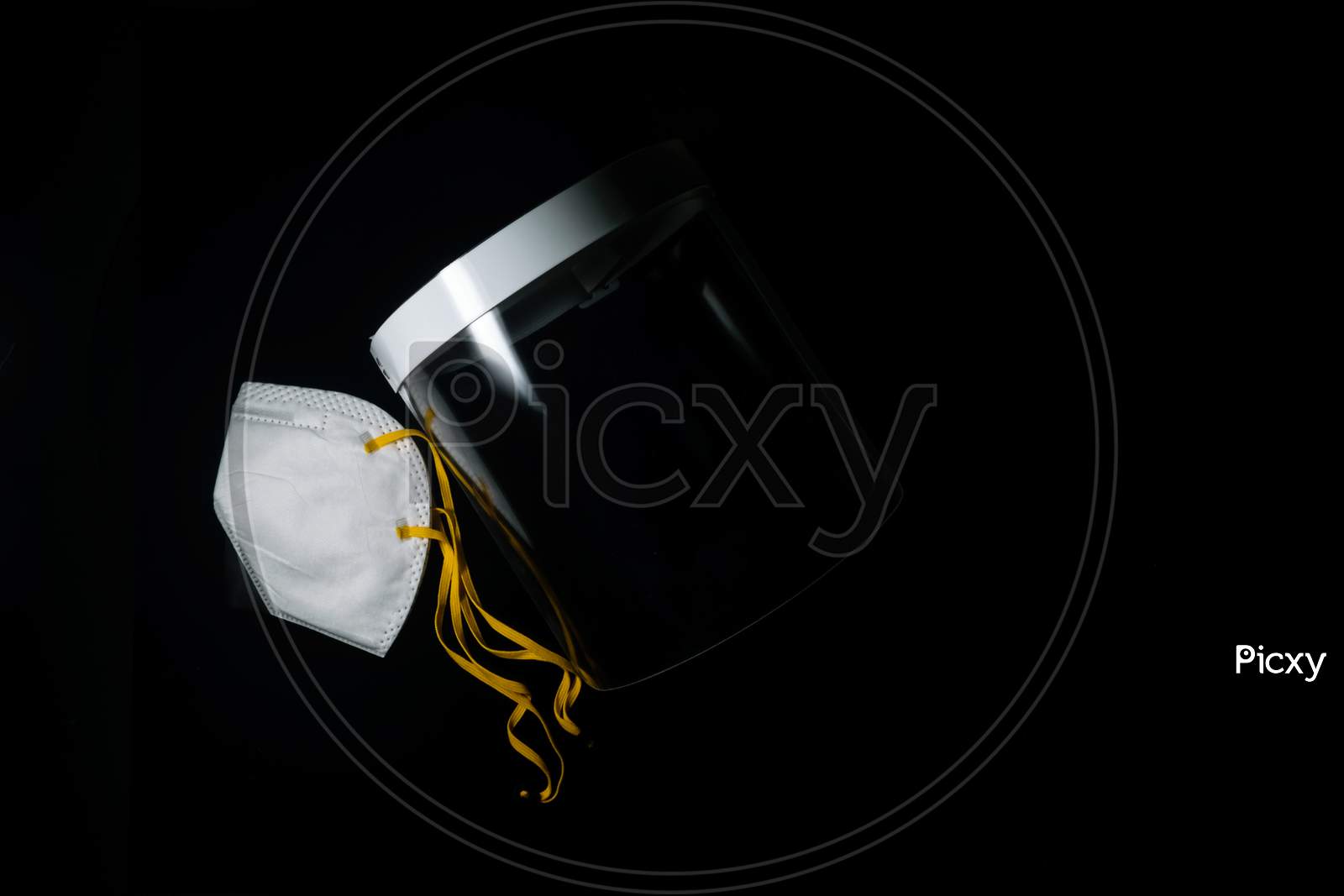 An Isolated Face Mask And Face Shield For Protection Against Covid 19 In A Dark Background