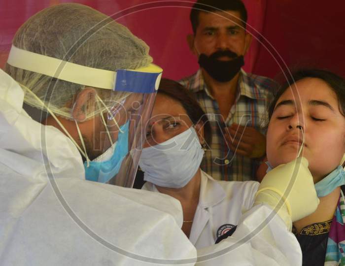 A Medic Collects Swab Sample From A Woman For Covid-19 Test, At Capital State Dispensary In Guwahati, India
